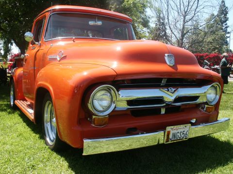 2000 Ford F-250 - This vintage Ford truck, likely a 1956 F-100, is presented in a vibrant orange hue with a prominent chrome grille.
