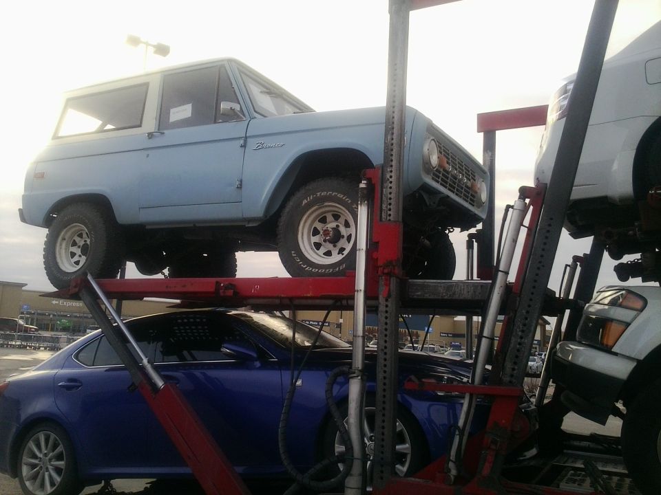 Light blue Ford Bronco, 3q-front view, on car carrier