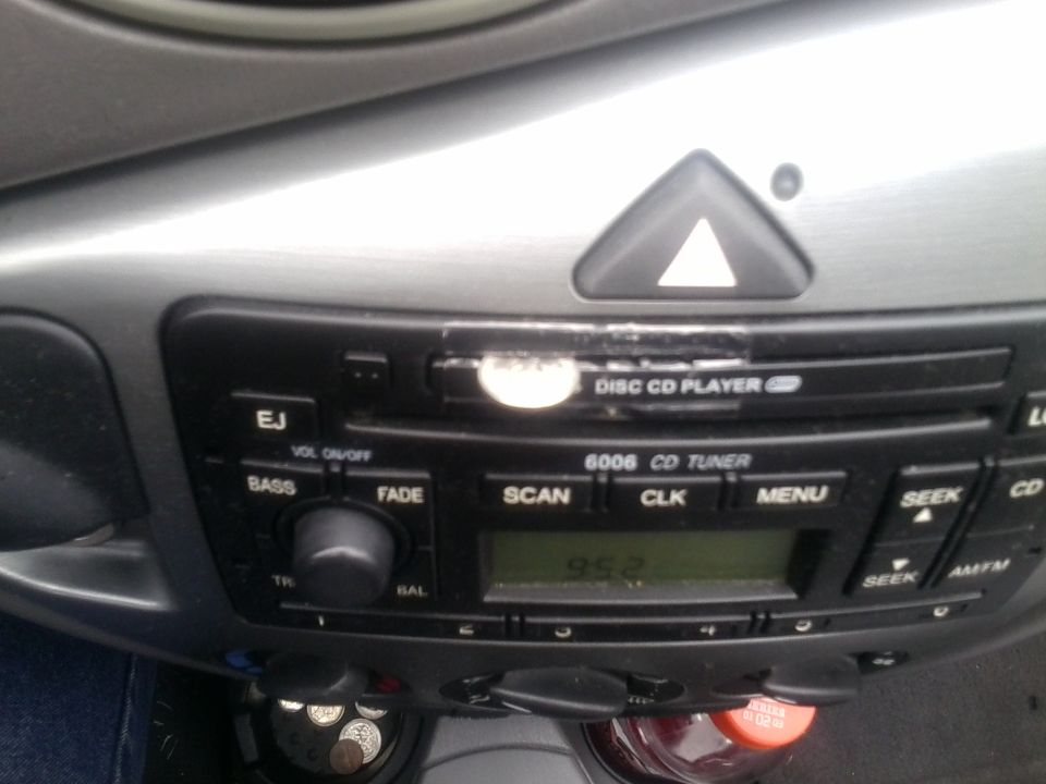 Close-up of a car's dashboard showing the radio and CD player controls, with a digital display showing '95.2'