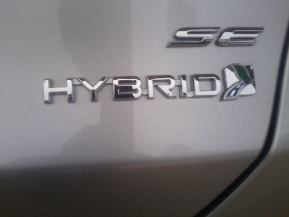 Close-up of a 'HYBRID SE' badge on a vehicle