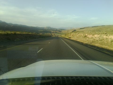 2000 Ford F-250 - View from inside a vehicle traveling on a highway through a mountainous landscape.
