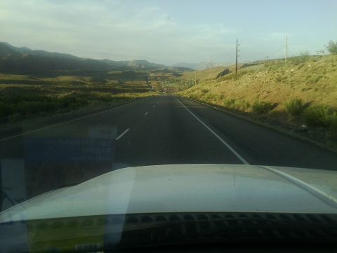 2000 Ford F-250 - Driving on a highway through a scenic, hilly terrain with power lines visible along the roadside.