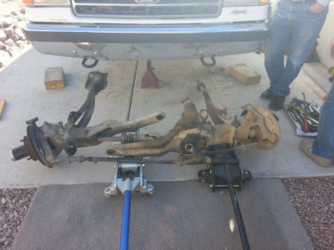 1991 Ford Bronco - The front axle assembly of a 1991 Ford Bronco is shown removed and supported by jacks.