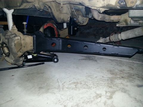 1991 Ford Bronco - Close-up view of lift kit components being installed on a vehicle's undercarriage.