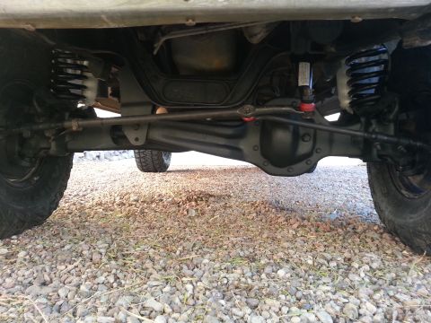 1991 Ford Bronco - The underside of a vehicle displays its suspension and differential, suggesting modifications for increased ground clearance.