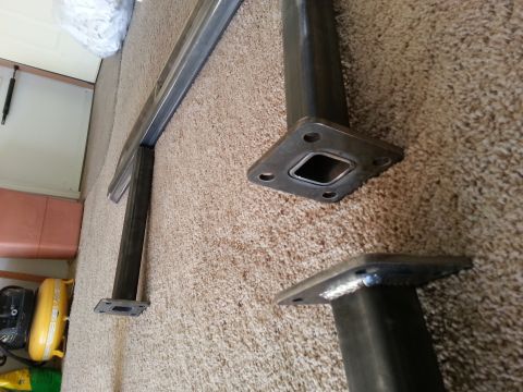 1991 Ford Bronco - Unidentified metal components, possibly for a lift kit, are shown on a carpeted floor. The Supermotors logo is visible in the lower right c…