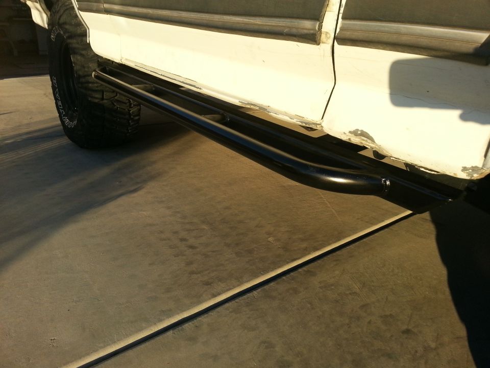 White SUV side view showing black tubular side steps and large tires