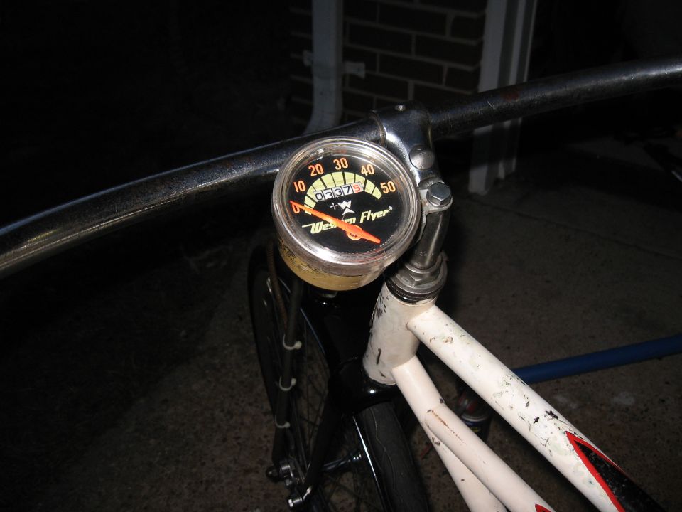 Bicycle speedometer with "Western Flyer" text and orange needle