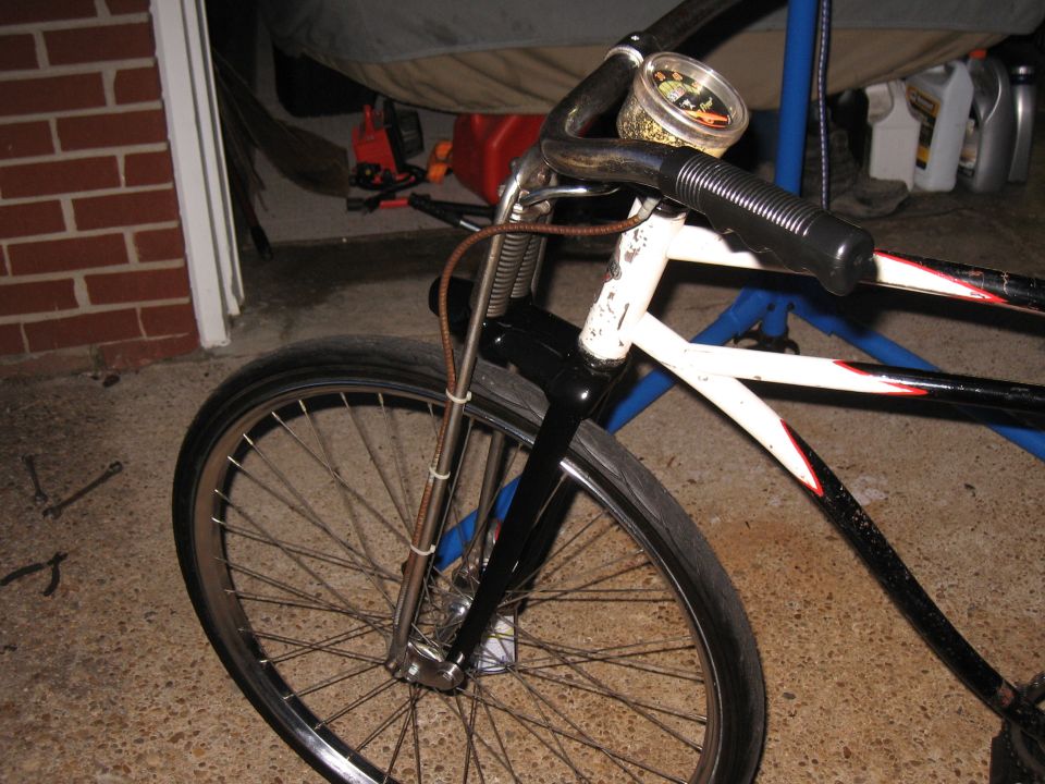 Front wheel and handlebars of a bicycle with a small gauge on the handlebars
