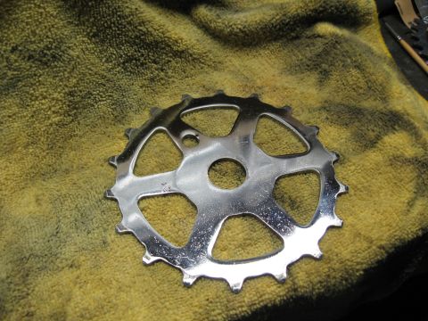 1994 Ford Bronco - A shiny chrome bicycle chainring rests on a textured yellow cloth, possibly awaiting installation or cleaning.