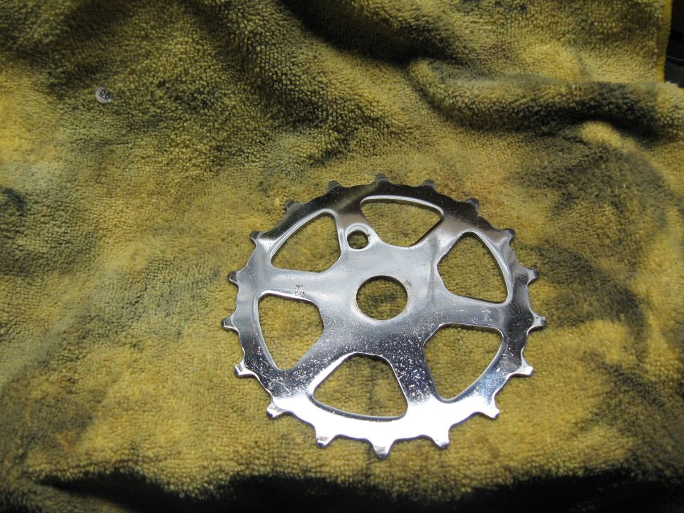 Chrome bicycle chainring on yellow towel
