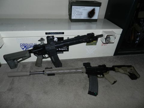 1996 Ford Bronco - Two assault rifles and an ammunition box are displayed on a carpeted floor in front of a storage safe.
