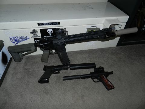 1996 Ford Bronco - Three firearms, including an AR-15 style rifle and two handguns, are displayed on a carpeted surface.