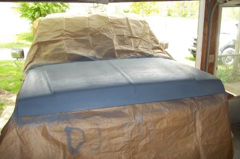 1990 Ford Bronco - The hood and fender of a 1990 Ford Bronco are covered in paper, likely for painting or protection.