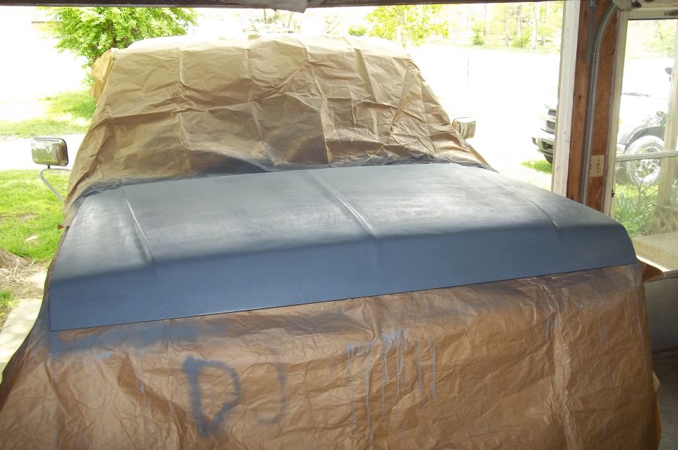1990 Ford Bronco hood and fender covered in paper, front view