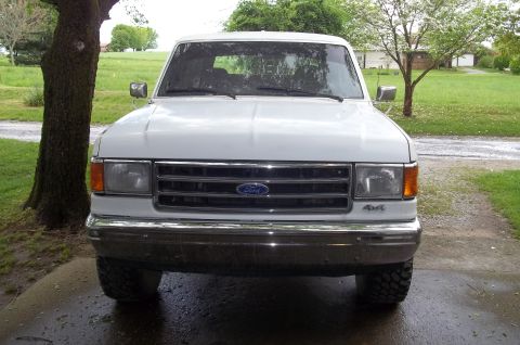 1990 Ford Bronco - This 1990 Ford Bronco is shown from the front, parked on a wet driveway.