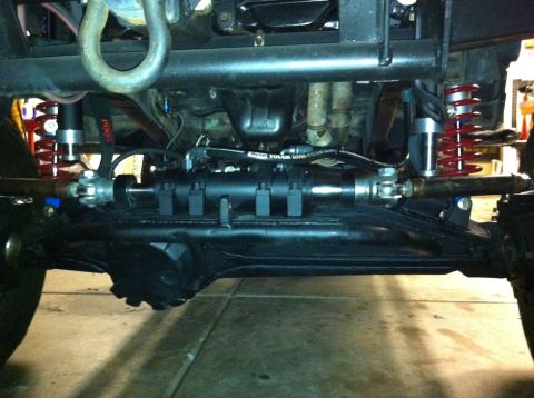 1987 Suzuki Samurai - Undercarriage view of a vehicle's front axle and suspension system.