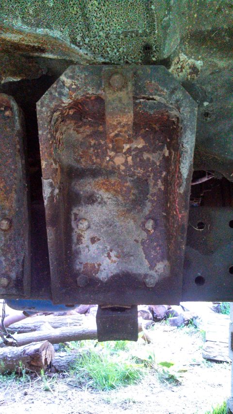 1979 Ford Bronco - Close-up view of a heavily rusted metal bracket, likely part of a vehicle's undercarriage.