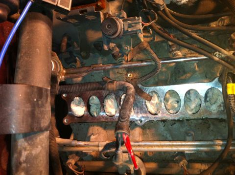 1996 Ford Bronco - Close-up view of an engine manifold's intake ports, partially obscured.