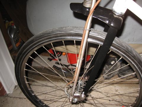 1994 Ford Bronco - The front wheel and suspension of a bicycle are shown in this close-up shot.