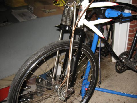 1994 Ford Bronco - Close-up of a bicycle's front wheel and suspension system, showing its black frame and decorative white accents.