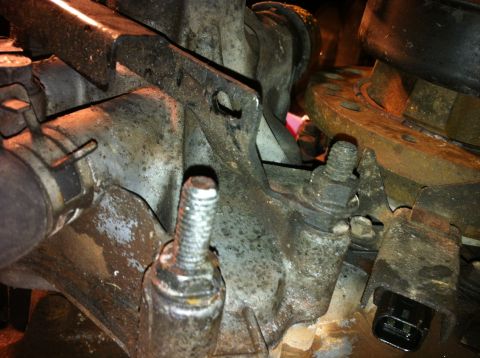 1996 Ford Bronco - Detail shot of engine parts, including bolts and metal brackets, with some rust and grime visible.