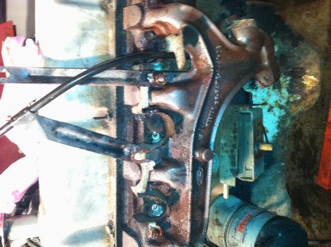 1996 Ford Bronco - Close-up of a corroded engine part with visible hoses and fasteners.