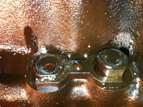 1996 Ford Bronco - This image shows engine components, likely part of a larger assembly, with visible bolts and oil residue.