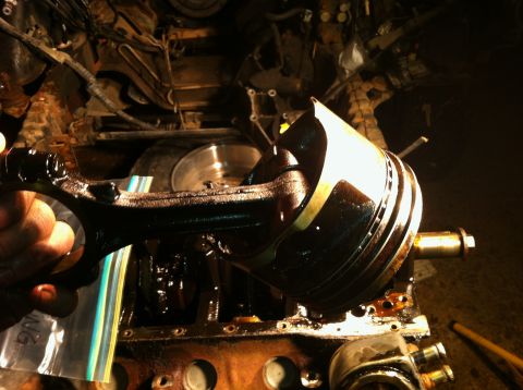1996 Ford Bronco - A close-up view shows a piston and connecting rod assembly removed from an engine block, indicating internal engine work.