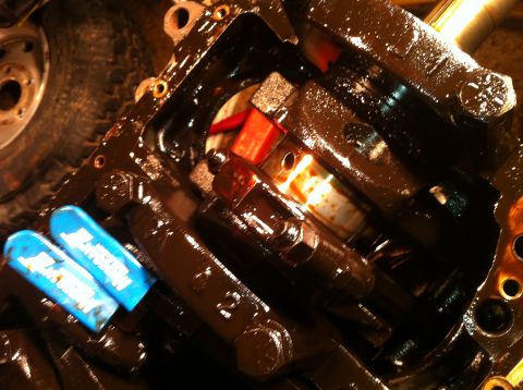 1996 Ford Bronco - Close-up of an engine block's internal components, including the crankshaft, covered in oil.