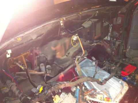 1996 Ford Bronco - The interior of a vehicle is shown with the dashboard removed, revealing complex wiring and internal parts.