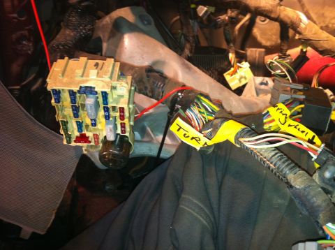 1996 Ford Bronco - Close-up of a vehicle's interior wiring harness and fuse box, with labels indicating electrical functions.