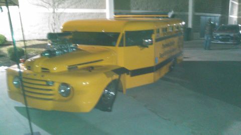 1979 Ford Bronco - This heavily modified bus features a prominent V8 engine and a distinctive yellow and black paint scheme.