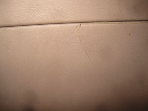 1993 Ford Bronco - Close-up of a tan interior panel showing wear and tear, including a visible scratch.