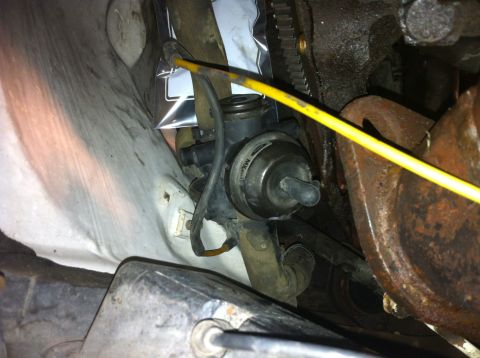1992 Ford Bronco - A close-up view of a vehicle's engine bay shows a vacuum actuator with attached hoses and wiring.