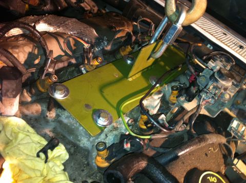 1992 Ford Bronco - Installing a yellow plate in the engine bay, with various engine components and wiring present.