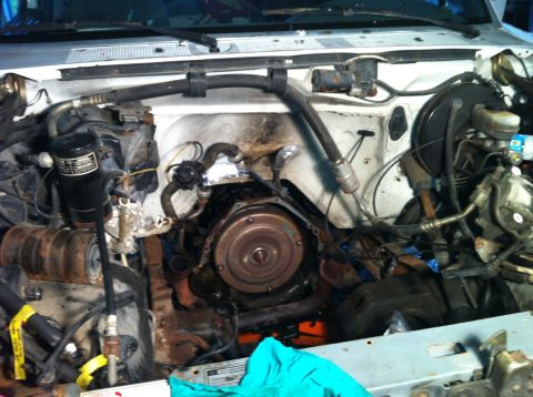 1992 Ford Bronco - The engine bay of a vehicle is shown with the transmission and various engine components exposed.