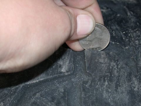 1994 Ford Bronco - Checking tire tread depth with a quarter coin.