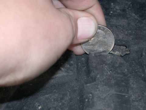 1994 Ford Bronco - A quarter is used to show the depth of a hole in a tire tread.