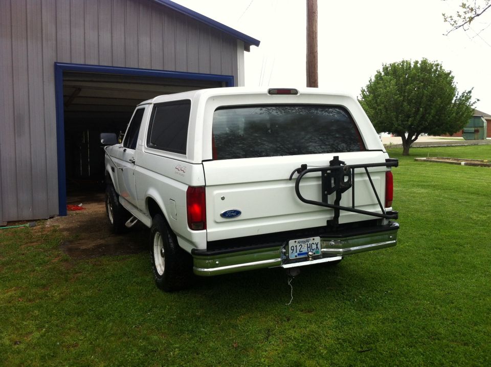White 1992 Ford Bronco rear view with spare tire carrier and license plate 912 HCX