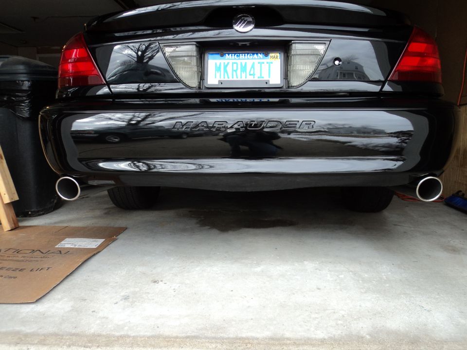 Black sedan rear with 'Marauder' badge, dual exhaust pipes, and Michigan license plate MKRM4IT