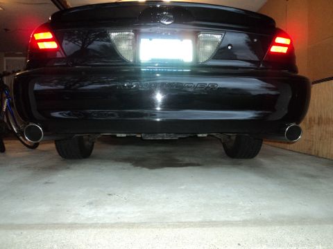 2004 Mercury Grand Marquis - The rear of a black 2004 Mercury Grand Marquis Marauder is visible, dual exhaust pipes and distinctive taillights.