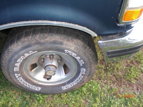 1993 Ford Bronco - Close-up of a 1993 Ford Bronco's front wheel, tire, and fender area.