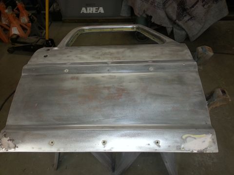 1967 Ford F-100 - Bare metal truck door, likely undergoing restoration or repair, with visible screw holes and some filler.