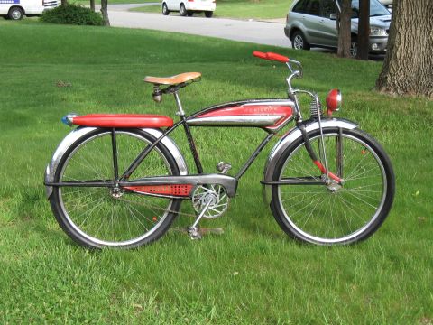 1994 Ford Bronco - A vintage red and chrome Schwinn bicycle is parked on a grassy lawn, with other vehicles visible in the background.