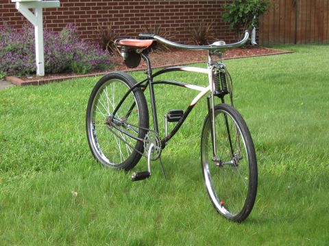 1994 Ford Bronco - This vintage bicycle features a unique frame design and a brown leather seat, set against a backdrop of green grass and a brick wall.