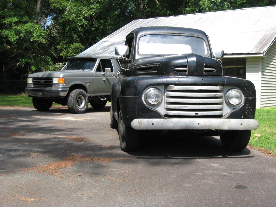 1948 Ford F-series truck in front of a gray Ford Bronco