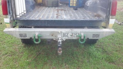 1983 Ford F-250 - This truck's rear bumper features a heavy-duty tow hitch and green D-rings, with a Georgia license plate visible.