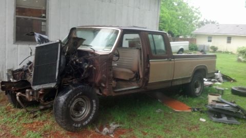 1983 Ford F-250 - Pickup truck with significant front-end damage, parked outdoors.
