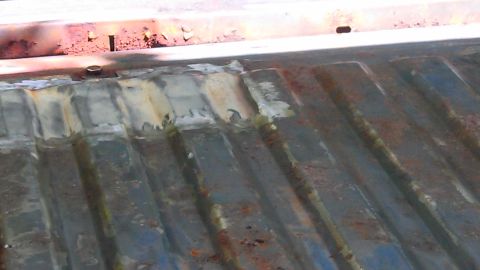 1979 Ford Bronco - Close-up view of a worn and patched truck bed, showing signs of rust and repair work.